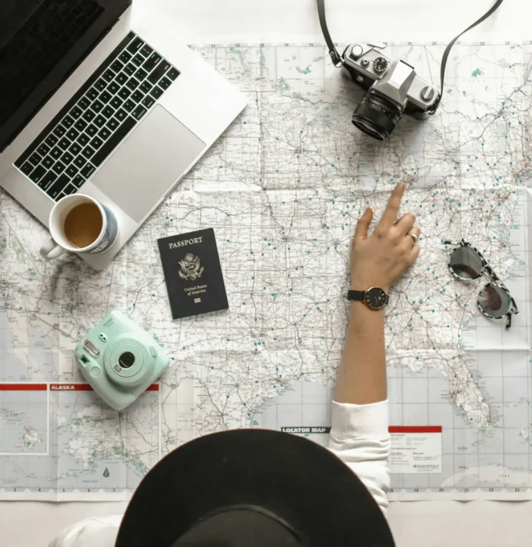 Hand pointing at a world map while planning a trip