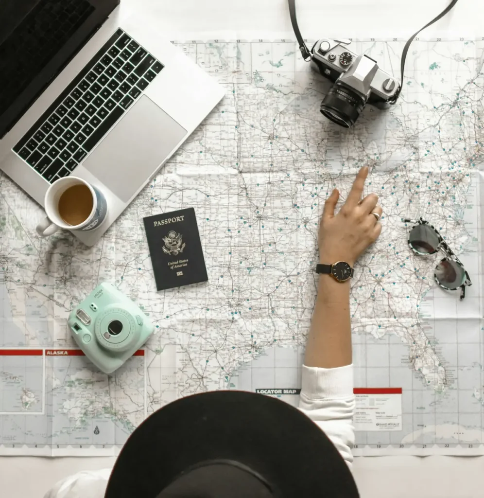 Hand pointing at a world map while planning a trip