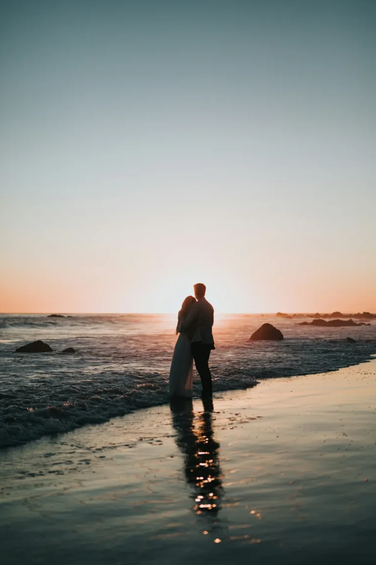 Couple in silhouette watching the sunset on a beach